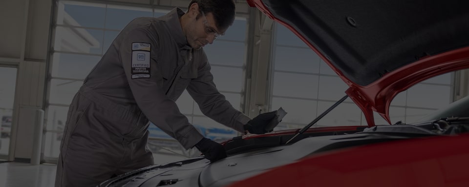 A Certified Service technician attaching a wheel to a GM EV vehicle.