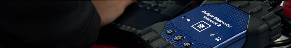 Certified Service technician on a laptop pulling up a vehicle's maintenance plan and schedule.