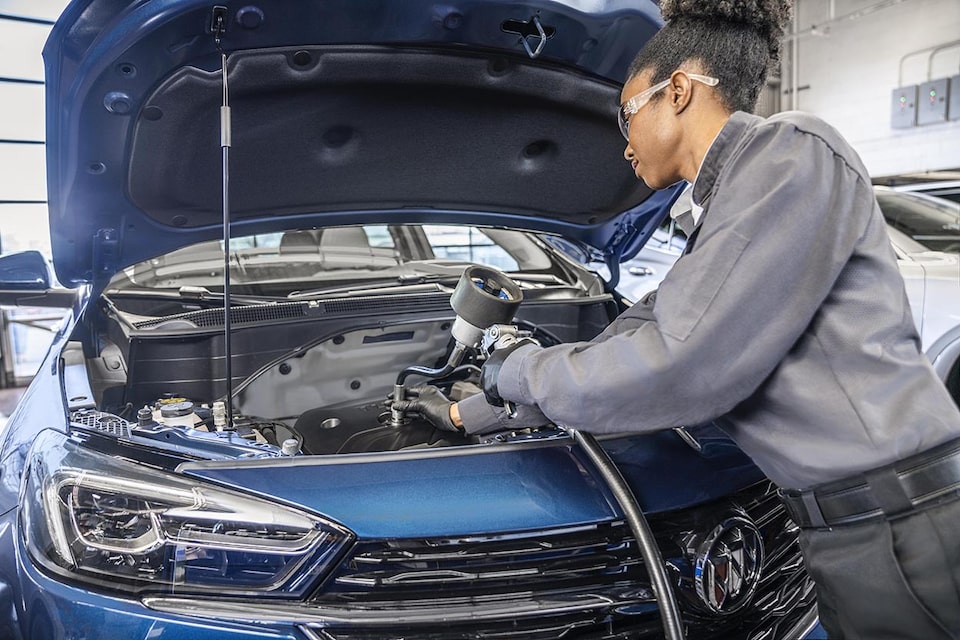 A Certified Service technician changing a vehicle's oil