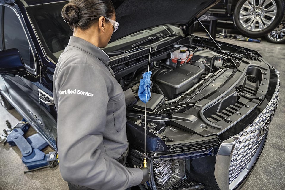 A Certified Service technician checking the oil level