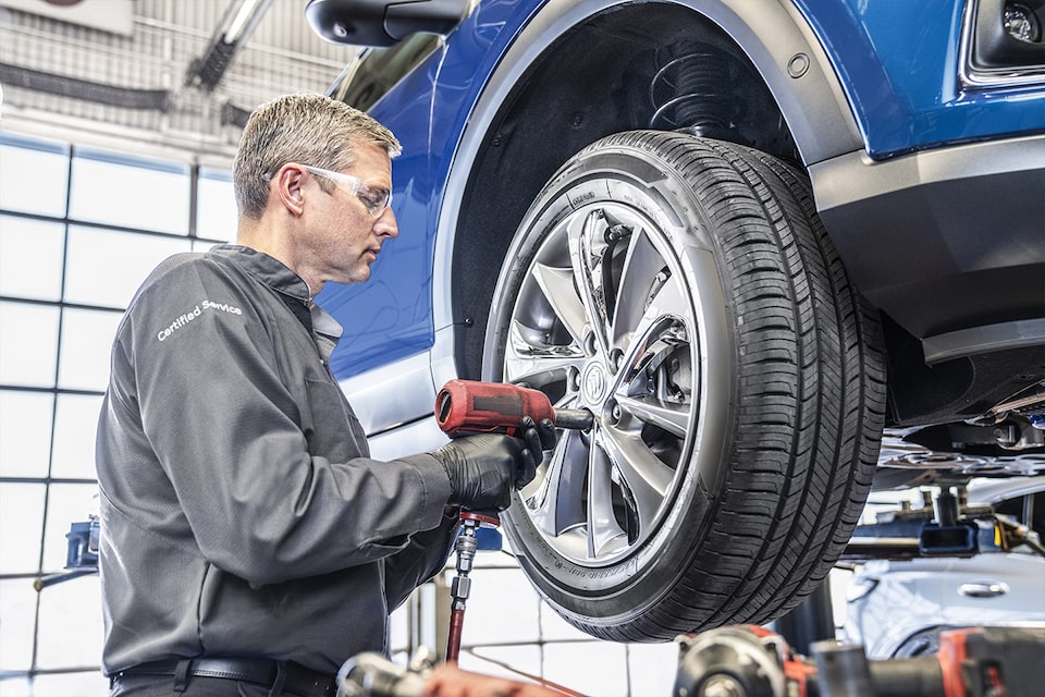 A Certified Service technician changing a tire